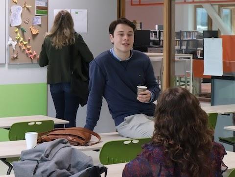 AI trainer geeft een deelnemer persoonlijke begeleiding achter de laptop tijdens een praktische cursus.