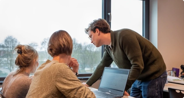 Trainer helpt een deelnemer bij het uitwerken van een ChatGPT opdracht