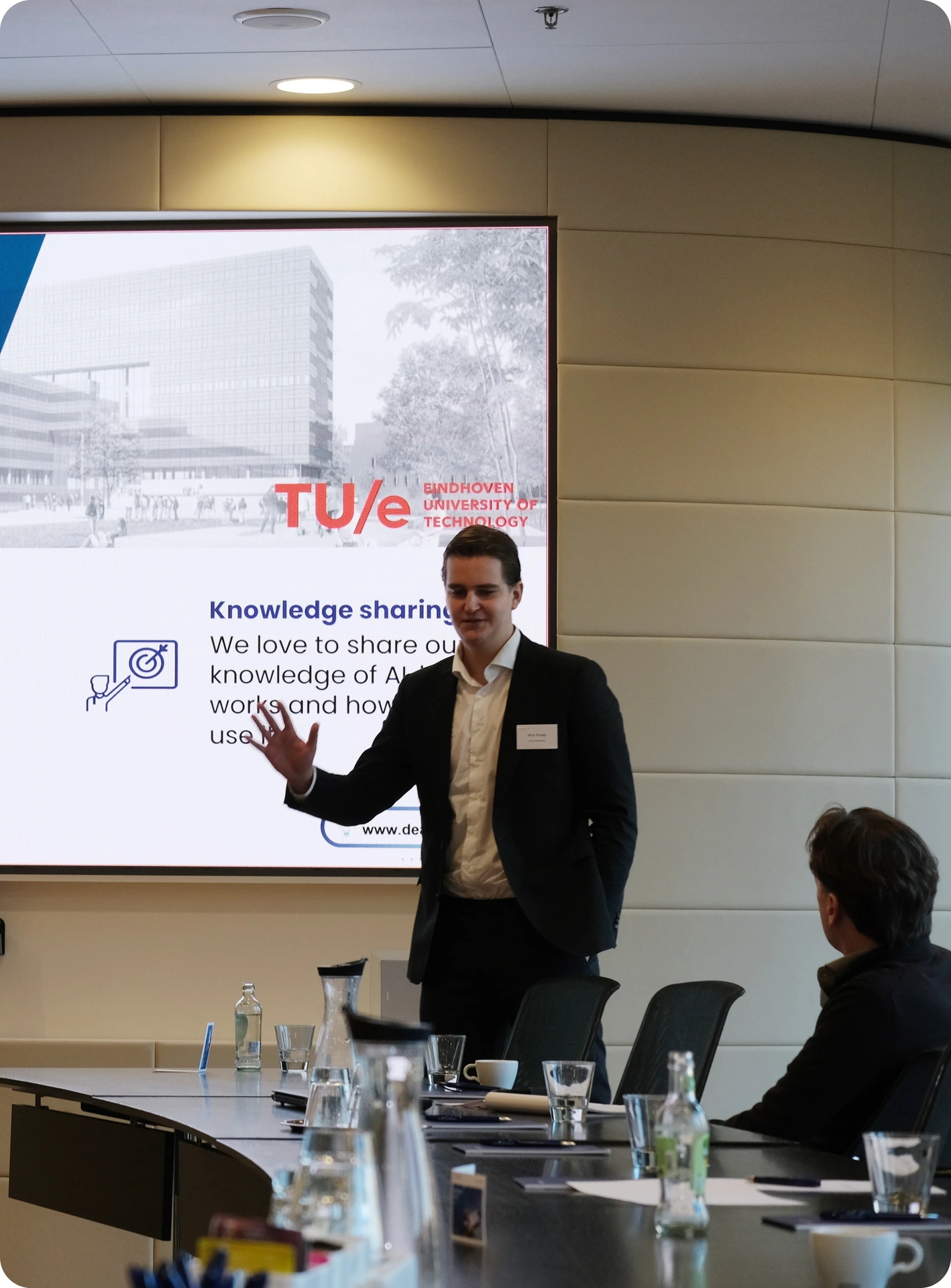 Een trainer geeft een presentatie met een scherm waarop het TU/e logo staat.