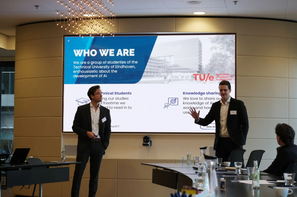 Twee sprekers geven een presentatie op een podium tijdens een AI workshop.