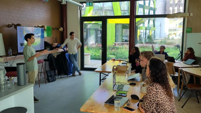 professionals werken geconcentreerd op hun laptops aan AI-opdrachten tijdens een in-company workshop